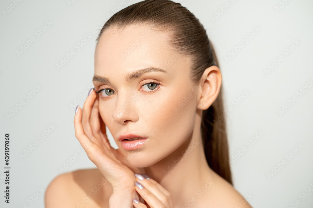 Natural skincare. Beauty face. Health wellness. Confident woman with nude makeup touching perfect radiant skin isolated on neutral background.