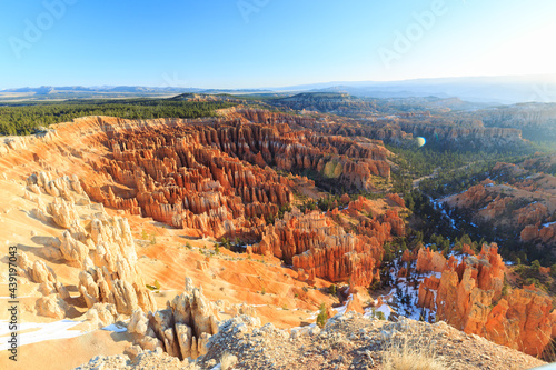 Hoodoos and canyons - red painted faces around the rims of a vast canyon desert and snow