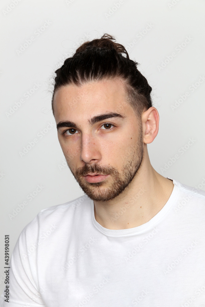 Attractive male model with long hair and beard posing in studio on isolated background. Style, trends, fashion concept. Attractive male model with long hair and beard posing in studio on isolated background. Style, trends, fashion concept.