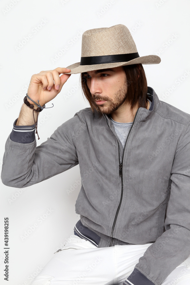 Attractive male model with long hair and beard posing in studio on isolated background. Style, trends, fashion concept. Attractive male model with long hair and beard posing in studio on isolated background. Style, trends, fashion concept.