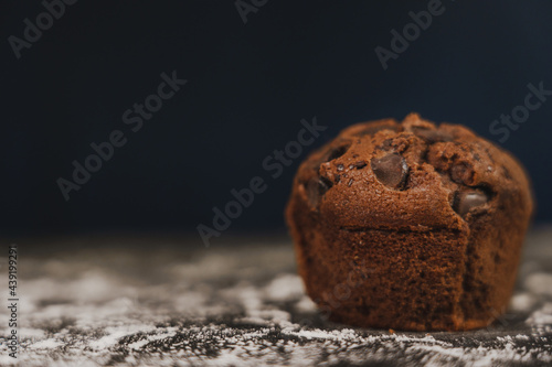 Homemade chocolate chips and vanilla muffin on a black background with sugar