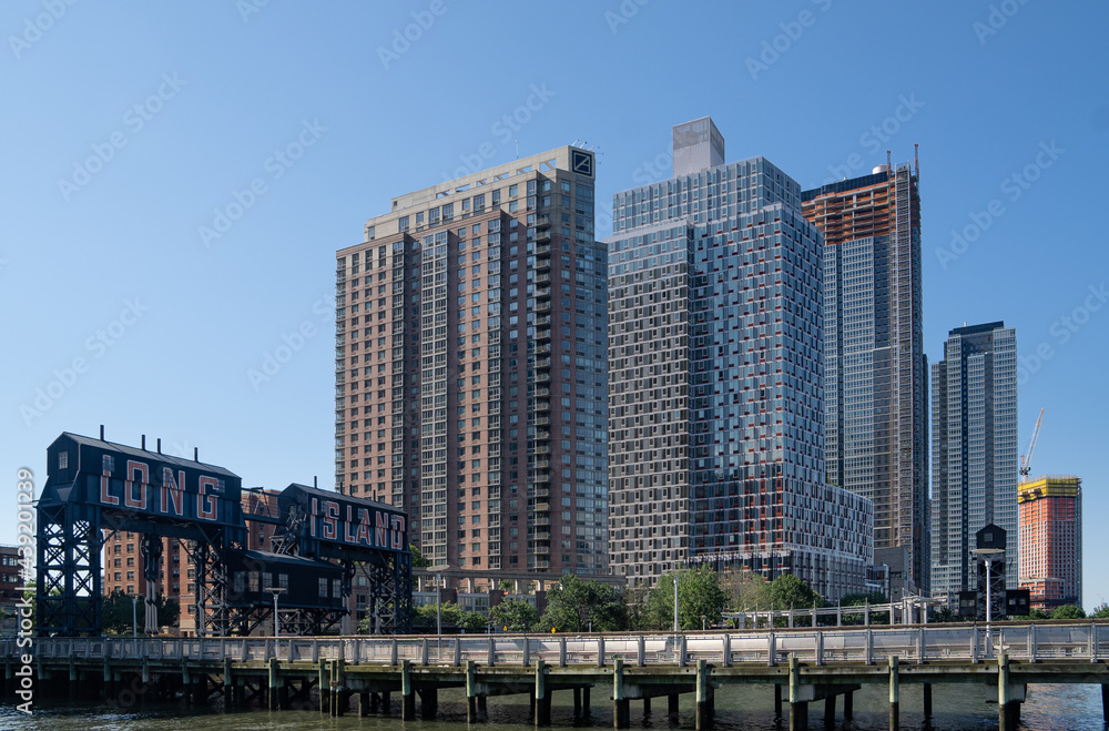Long Island City, NY - USA- June 13, 2021: A view of Gantry Plaza State Park, with transfer bridges, support gantries, and piers. on the East River in the Hunters Point section of Long Island City. Long Island City, NY - USA- June 13, 2021: A view of Gantry Plaza State Park, with transfer bridges, support gantries, and piers. on the East River in the Hunters Point section of Long Island City.