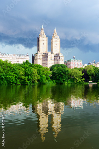 Upper West Side Skyline reflects in the lake of Central Park, New York City. Storm clouds.