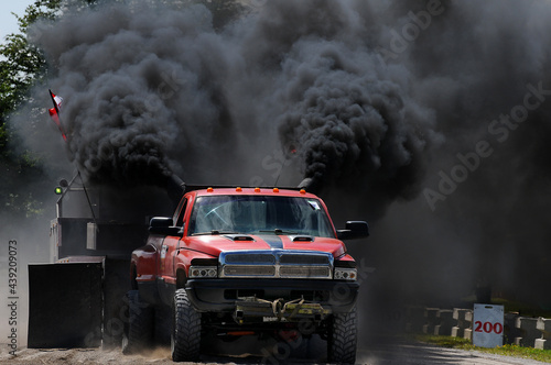 red truck with lots of black diesel smoke at a tractor pull photo