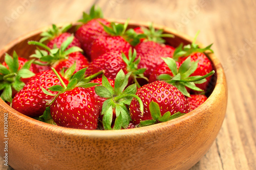 Fresh strawberries in a bowl on a wooden table. Summer food  fruit background  delicious food. Side view  copy space.