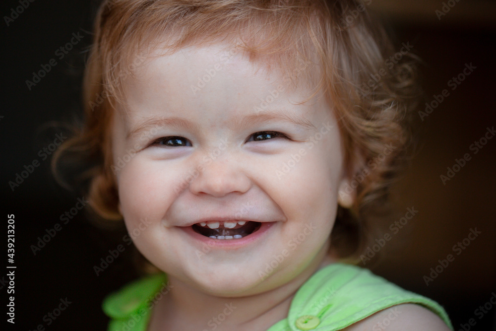 Portrait of a happy laughing baby. Close up positive kids face. Smiling infant, cute smile.