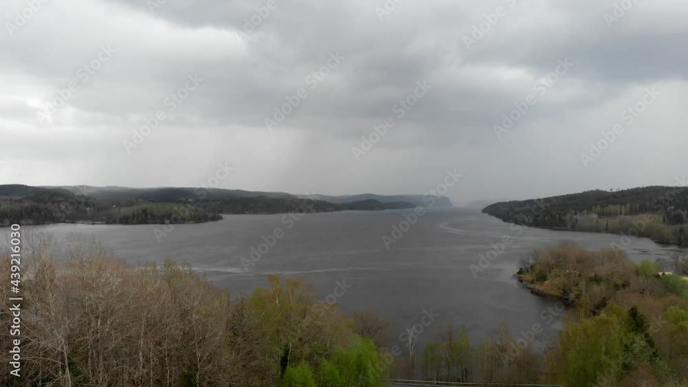 Aerial shot of dramatic scenery of storm clouds over lake in forest. Stunning aerial shot of a lake with a storm incoming. Beautiful monsoon landscape with mountains, forest and lake. Aerial View. Aerial shot of dramatic scenery of storm clouds over lake in forest. Stunning aerial shot of a lake with a storm incoming. Beautiful monsoon landscape with mountains, forest and lake. Aerial View.