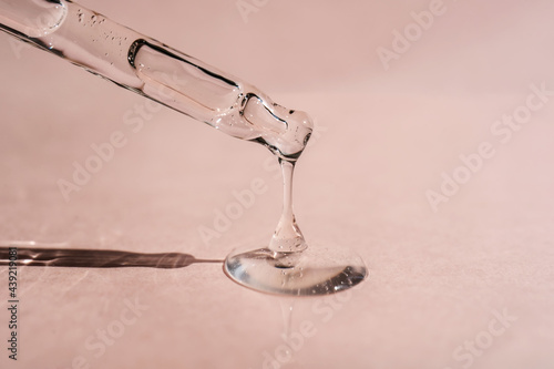 A drop of cosmetic oil falls from the pipette