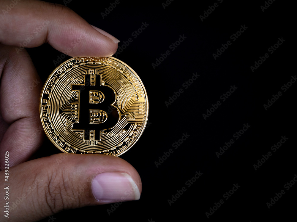 Bitcoin technology background. Close-up golden bitcoin in businessman's hand on black background with copy space. Digital Cryptocurrency investment concept background. Bitcoin technology background. Close-up golden bitcoin in businessman's hand on black background with copy space. Digital Cryptocurrency investment concept background.