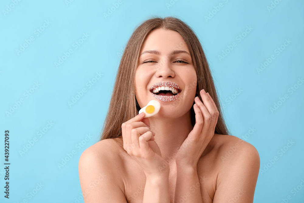 Beautiful young woman with creative makeup and sweet candy on color background Beautiful young woman with creative makeup and sweet candy on color background