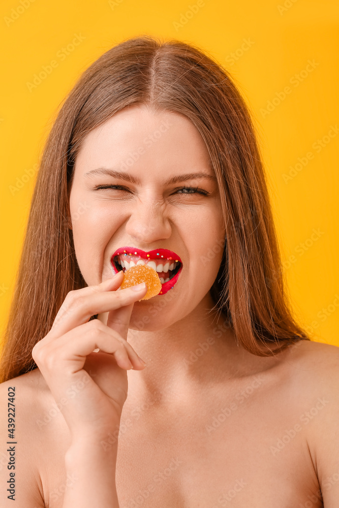 Beautiful young woman with creative makeup and candy on color background Beautiful young woman with creative makeup and candy on color background