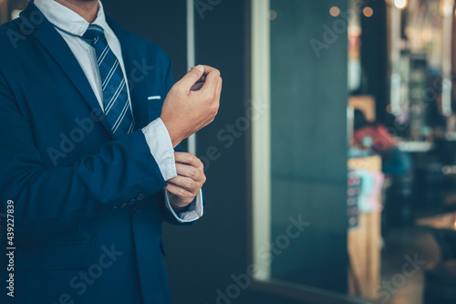Εκτύπωση καμβά businessman wearing business suit fasten cufflink or button on sleeve of classic jacket and factory background