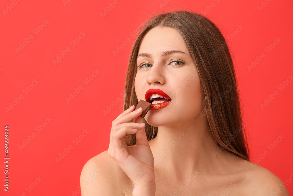 Beautiful young woman with sweet chocolate on color background Beautiful young woman with sweet chocolate on color background