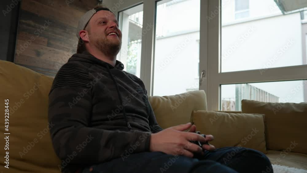 GAMING - Millennial man FINALLY WINS at video game, raises fist, medium shot GAMING - Millennial man FINALLY WINS at video game, raises fist, medium shot