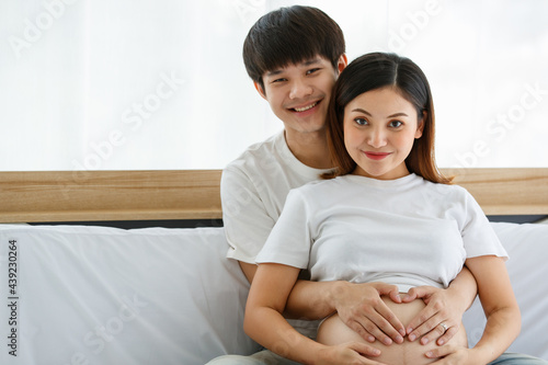 warmth lovely family concept. Male and female lover touching the belly of a pregnant woman with love and care. Focus on the hands of husband and wife