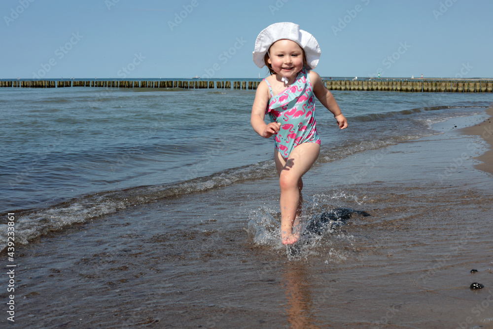 Adorable happy smiling little girl on beach vacation