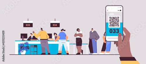 mix race people looking at display number board in waiting room electronic queuing system queue management