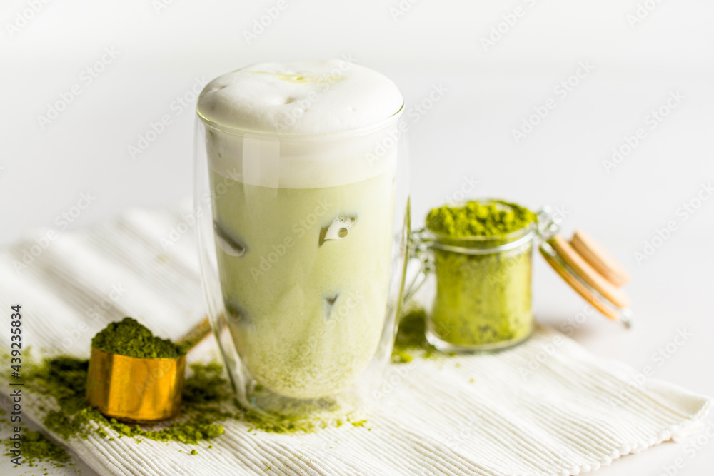 Matcha green tea latte with ice cubes on the white background Matcha green tea latte with ice cubes on the white background