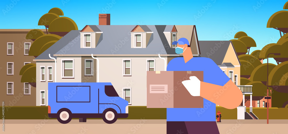 Obraz premium male courier in mask and gloves holding cardboard box contactless delivery medical courier service concept