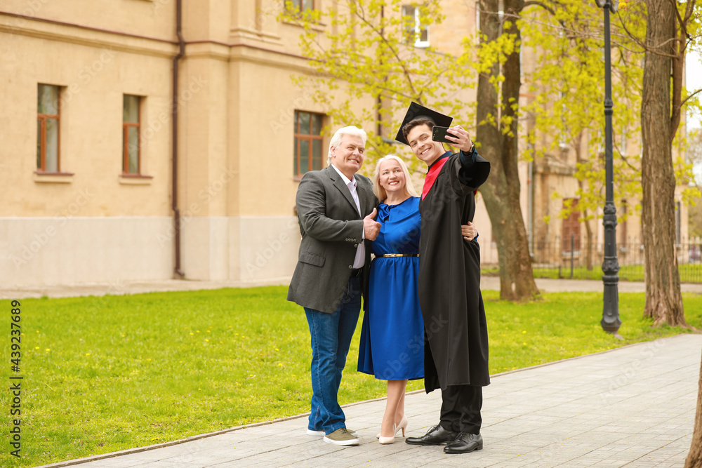Happy young man with his parents on graduation day Happy young man with his parents on graduation day