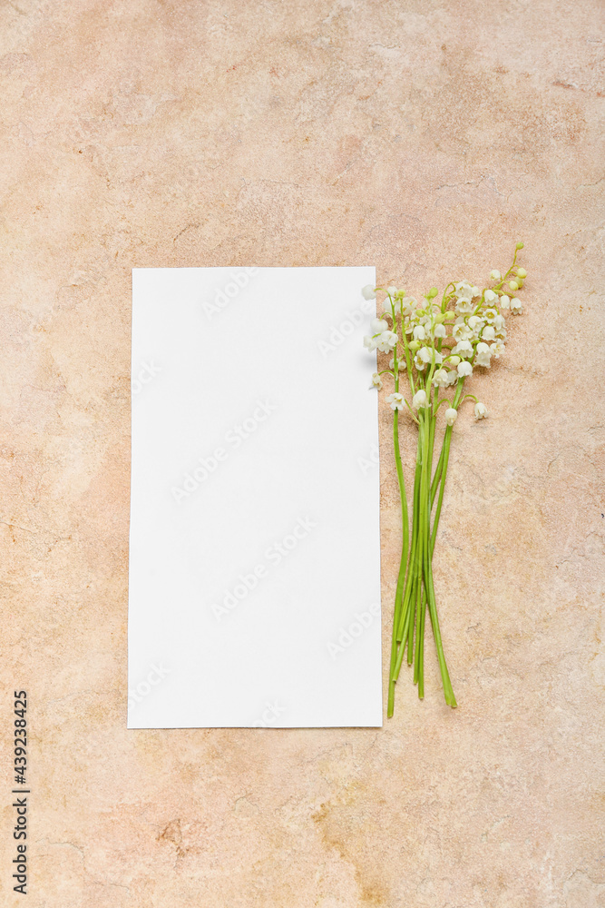 Beautiful lily-of-the-valley flowers and blank card on color background Beautiful lily-of-the-valley flowers and blank card on color background