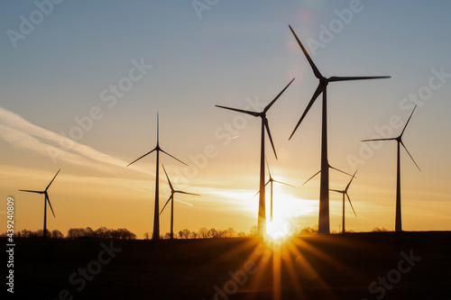 Silhouettes of wind turbines in the rising sun