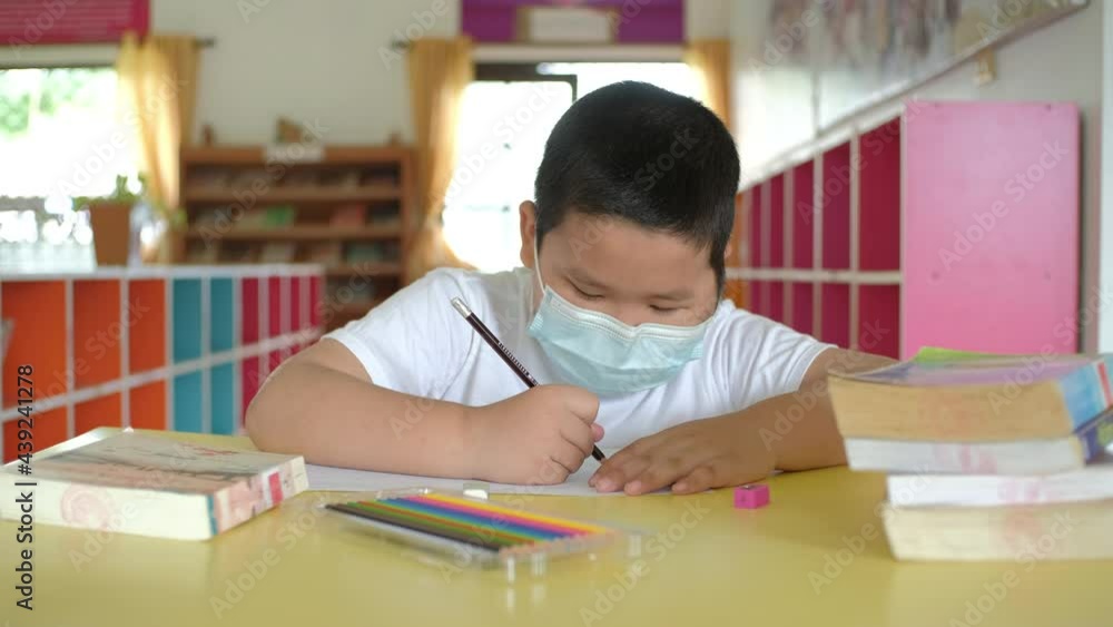 Back to School, Asian little child with face mask doing homework at school Back to School, Asian little child with face mask doing homework at school