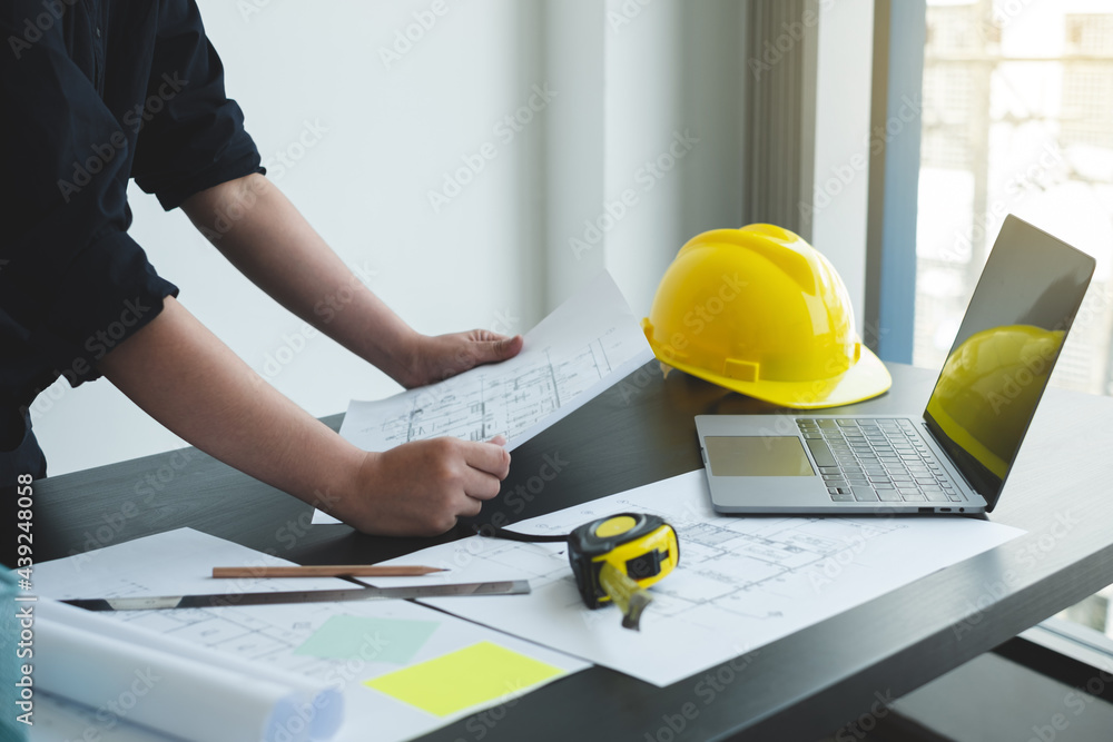Architects or engineers working construction and drawing construction plans, printing, writing on-site construction sites. Home design concept Architects or engineers working construction and drawing construction plans, printing, writing on-site construction sites. Home design concept