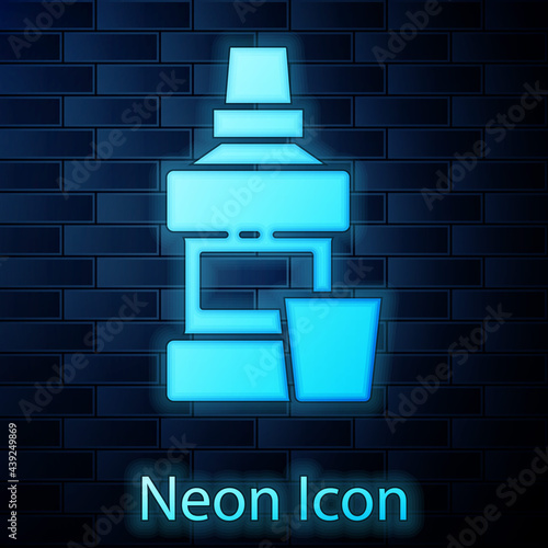 Glowing neon Mouthwash plastic bottle and glass icon isolated on brick wall background. Liquid for rinsing mouth. Oralcare equipment. Vector