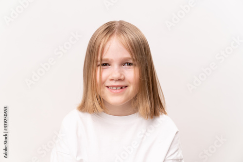cheerful and happy little girl with a haircut quad on a white background.