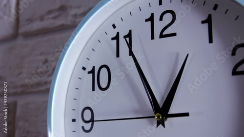 The wall clock, the time on the clock is five minutes to one. Business and  time concept with watch or clock on white wall