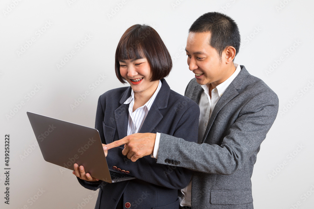 Asian businesswoman and businessman holding computer standing on white background. Asian businesswoman and businessman holding computer standing on white background.
