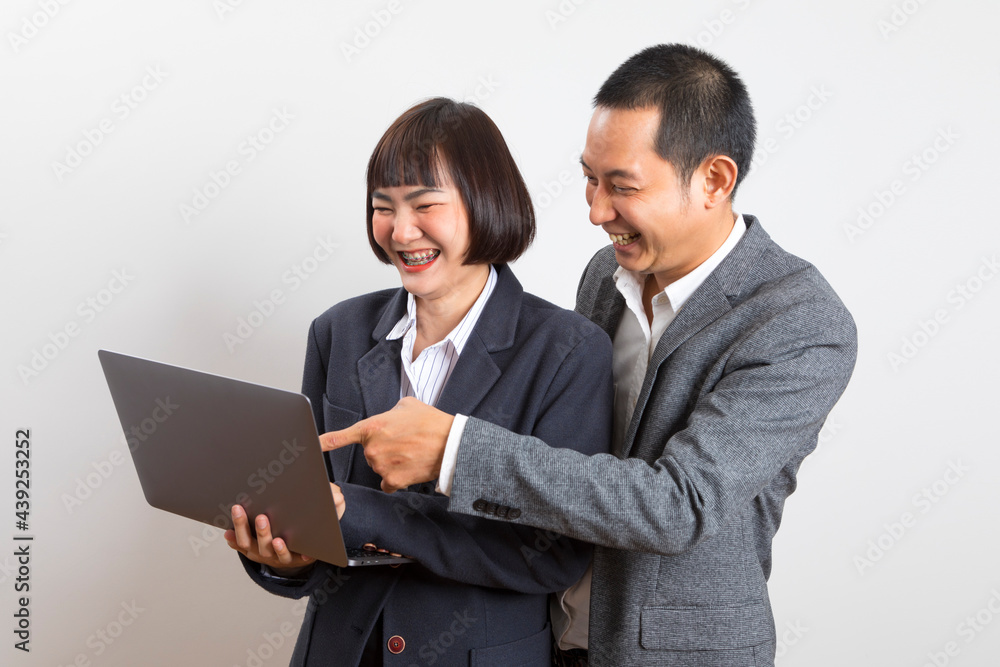 Asian businesswoman and businessman holding computer standing on white background. Asian businesswoman and businessman holding computer standing on white background.