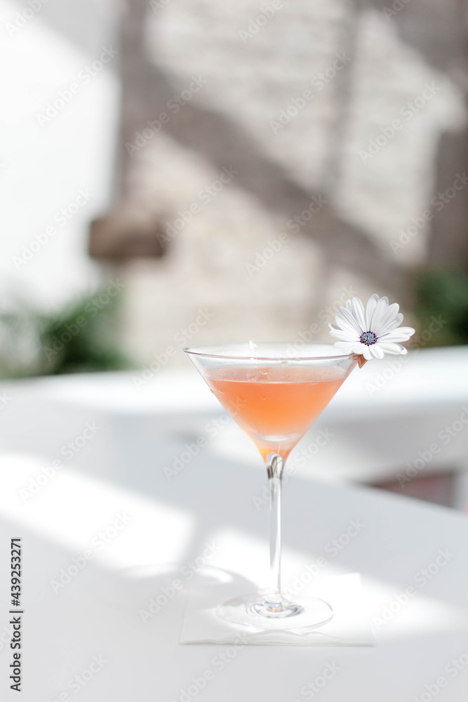 Summer cocktail garnished with flowers. Cold alcohol beverage on bar Summer cocktail garnished with flowers. Cold alcohol beverage on bar
