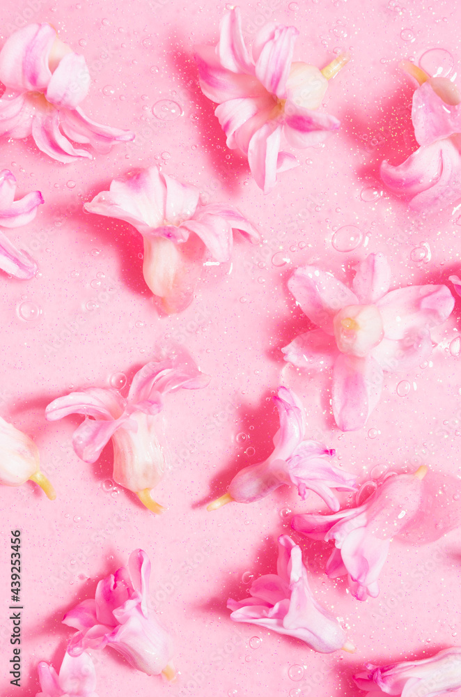 Fresh pink hyacinth flowers with glowing golden shimmer slime as abstract cosmetic pattern, vertical. Fresh pink hyacinth flowers with glowing golden shimmer slime as abstract cosmetic pattern, vertical.