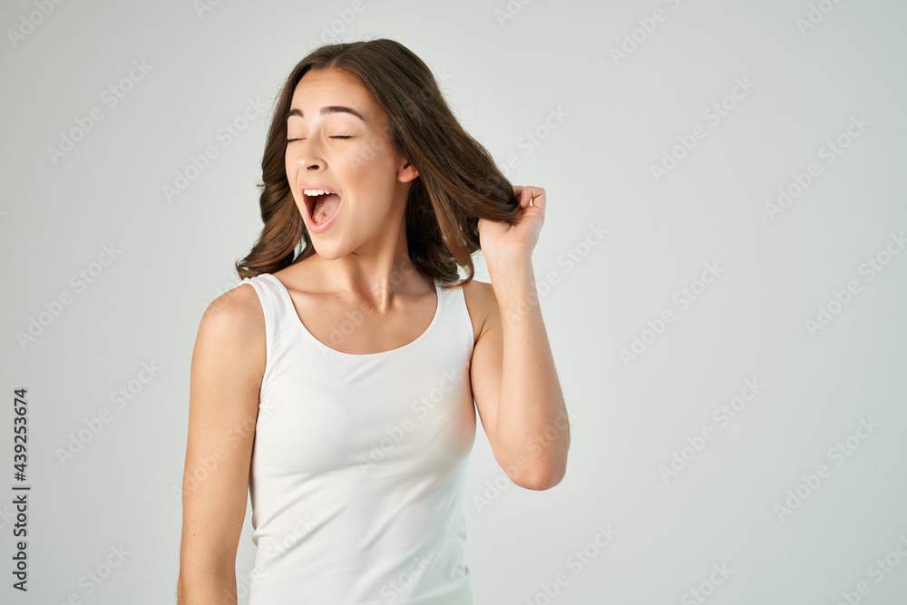 brunette in white t-shirt straightens her hairstyle cropped view isolated background brunette in white t-shirt straightens her hairstyle cropped view isolated background