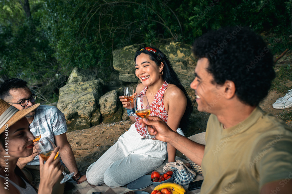Diverse group of friends enjoying picnic by the river. Diverse group of friends enjoying picnic by the river.