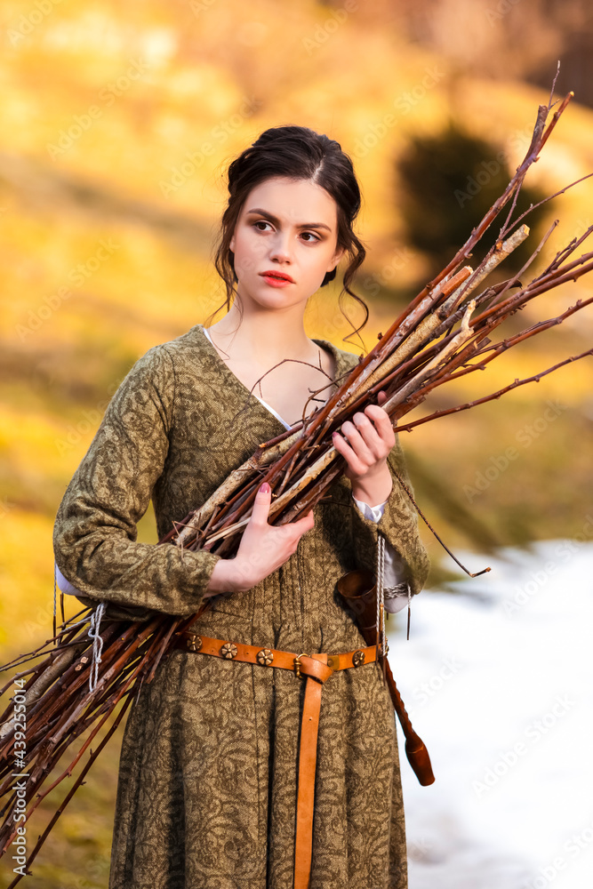 Natural Portrait of Sensual Caucasian Female in Village Dress With Pieces of Brushwoods in Hands Outdoor.