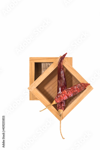 Sun dried red pepper arranged in wooden blocks on a white background