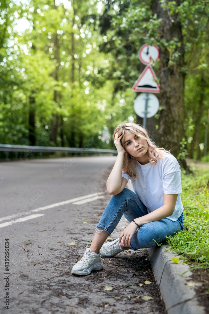 Young woman walking on asphalt road with forest trees Young woman walking on asphalt road with forest trees