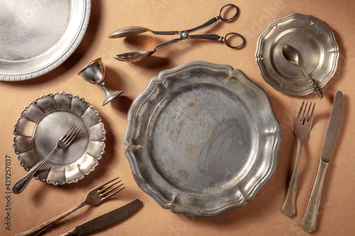 Картината върху платно Vintage silver tableware, overhead flat lay shot on a rustic background