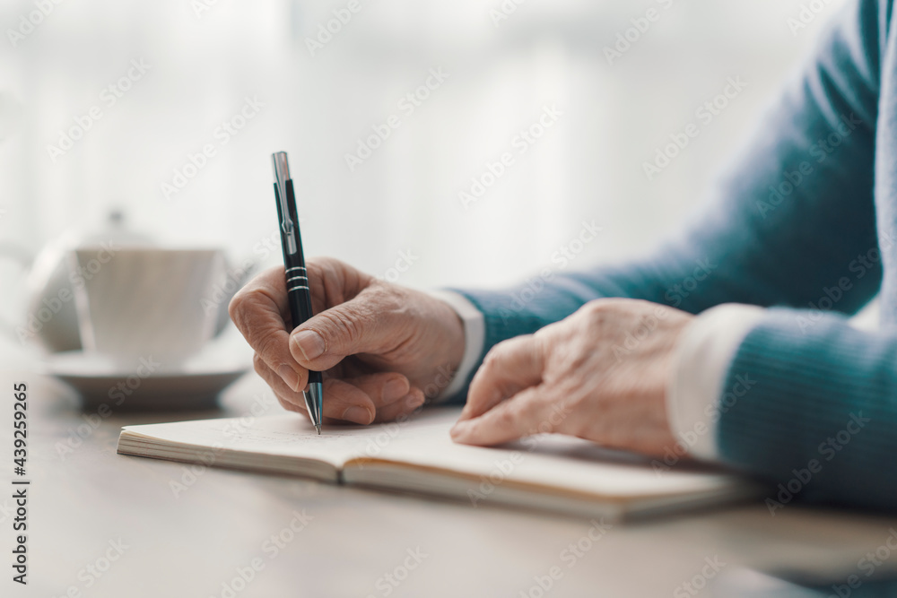 Senior woman writing on a notebook Senior woman writing on a notebook