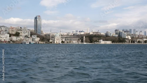 Amazing view of Dolmabahce Palace and Bosphorus from sea. Famous Istanbul cityscape, Dolmabahce camii and Bosporus at cloudy day photo