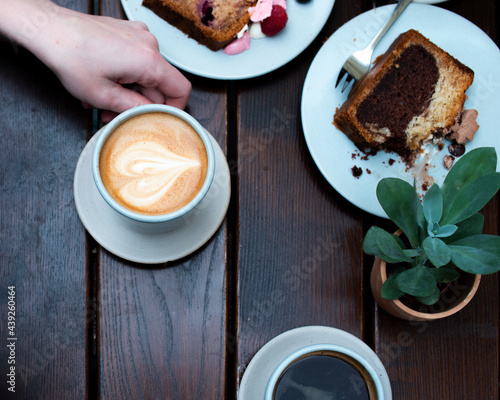 A cup of coffee with cake and plant
