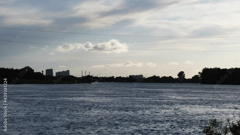 Urban landscape. A wide river against the background of the sunset sky and the city. The Kuban River in Krasnodar. Static frame Urban landscape. A wide river against the background of the sunset sky and the city. The Kuban River in Krasnodar. Static frame