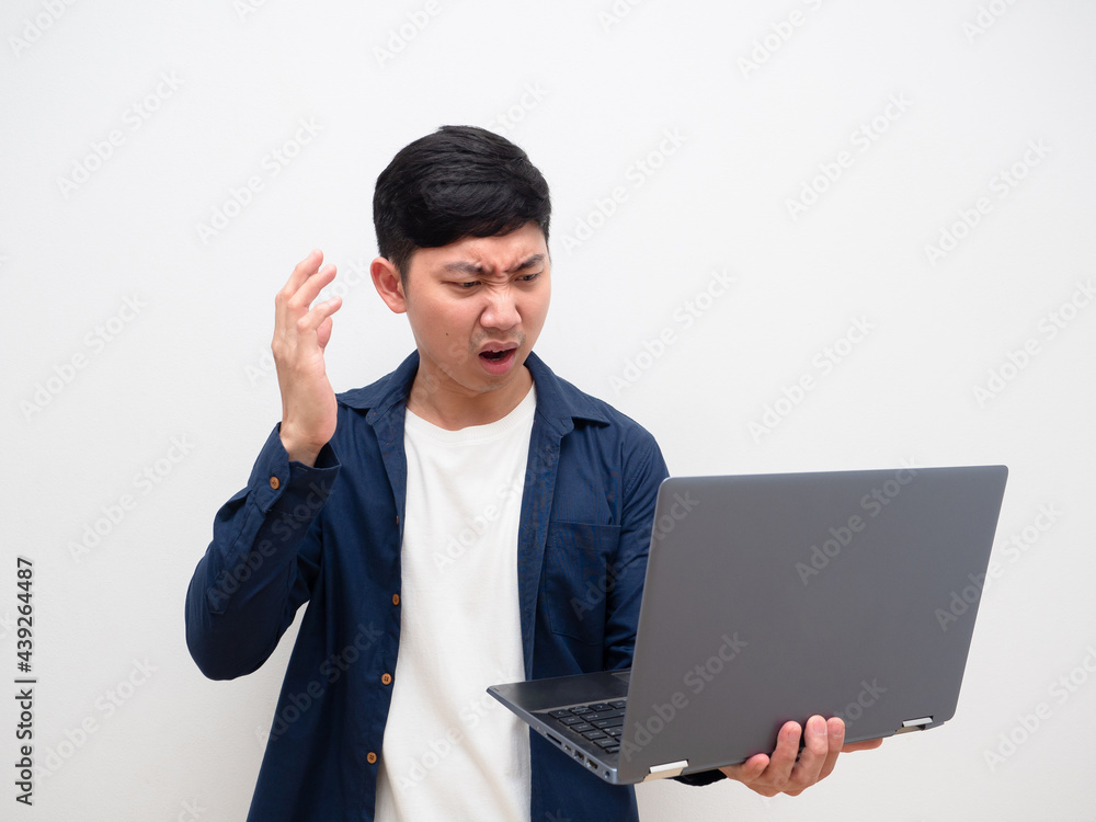 Asian man feel shocked and sad with laptop in hand on white isolated background Asian man feel shocked and sad with laptop in hand on white isolated background