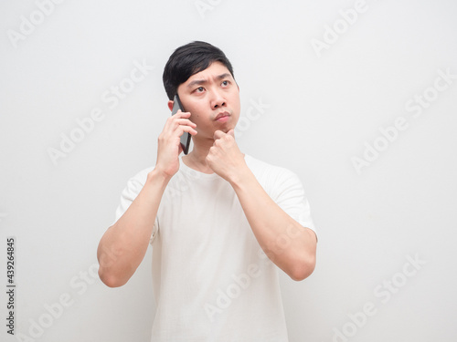 Asian man talking with cellphone thinking and decide serious face white background