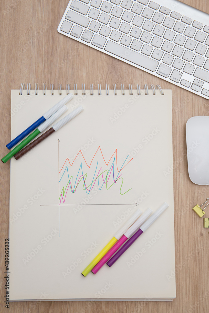 Drawing a graph of growth in a notebook on your desk at home.Wooden work table Drawing a graph of growth in a notebook on your desk at home.Wooden work table