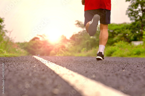 person running on the road in the morning with the sunrise.