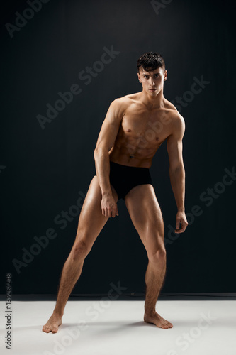 man in black shorts with a pumped body on a dark background model